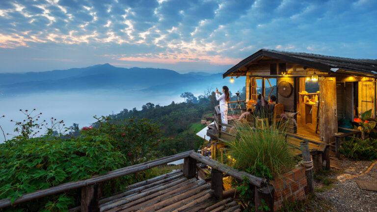 Woman taking a photo to morning mist at Phu Lang Ka, Phayao in T